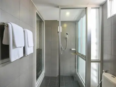 a bathroom with a shower with a glass door at Kitzio House Hotel Huai Kwang in Bangkok