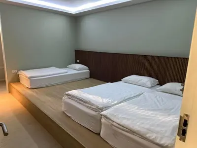 two twin beds in a room with a skylight at Kitzio House Hotel Huai Kwang in Bangkok