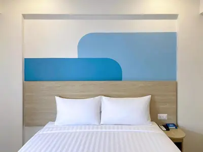 a bed with white sheets and a blue headboard at HOP INN Bangkok Bangna in Bangkok