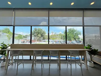a table and chairs in a room with a large window at HOP INN Bangkok Bangna in Bangkok