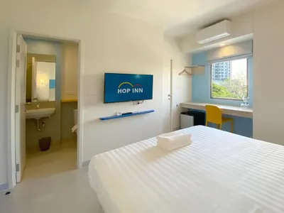 a bedroom with a bed and a sign on the wall at HOP INN Bangkok Onnut Station in Bangkok
