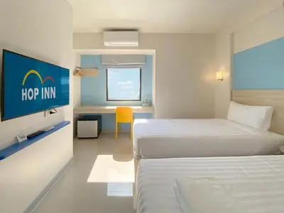 a hotel room with two beds and a sign that says hop inn at HOP INN Bangkok Onnut Station in Bangkok