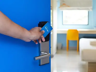 a hand holding a blue door with a handle at HOP INN Bangkok Onnut Station in Bangkok