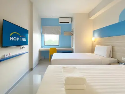 a hotel room with two beds and a tv at HOP INN Bangkok Krung Thonburi Station in Bangkok
