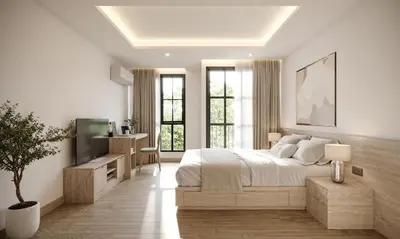 a white bedroom with a large bed and a television at Leon Lasalle Hotel and Residences in Bangkok