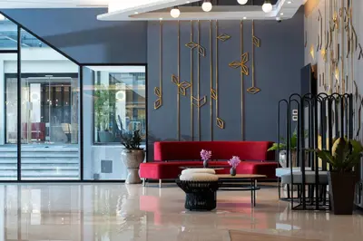 a living room with a red couch and a table at Centara Life Hotel Bangkok Phra Nakhon in Bangkok