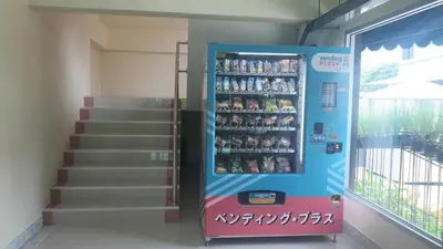a vending machine in a building with a staircase at หรรษาเพลส ลาดพร้าว 124 in Ban Bang Toei (1)