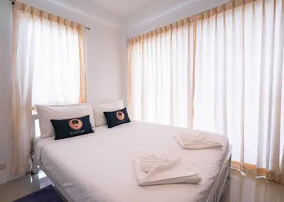 a bedroom with a white bed with two pillows on it at RQ Bangkok Sukhumvit 50 by Collection O in Amphoe Phra Khanong