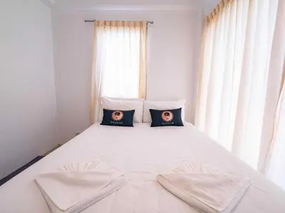 a bedroom with a white bed with two pillows on it at RQ Bangkok Sukhumvit 50 by Collection O in Amphoe Phra Khanong