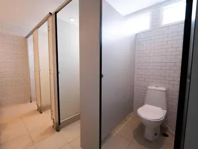 a bathroom with a toilet and a glass door at RQ Bangkok Sukhumvit 50 by Collection O in Amphoe Phra Khanong