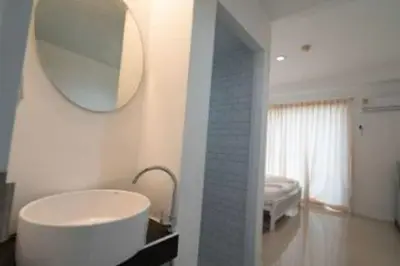 a bathroom with a large white tub and a mirror at RQ Bangkok Sukhumvit 50 by Collection O in Amphoe Phra Khanong
