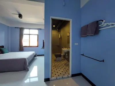 a blue bedroom with a bed and a bathroom at HOUSEMODE - BAANYAI @ Wongwian Yai in Bangkok
