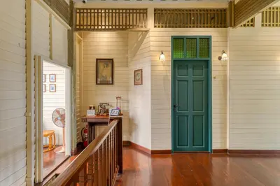 a hallway with a green door in a house at Priya Boutique House in Bangkok
