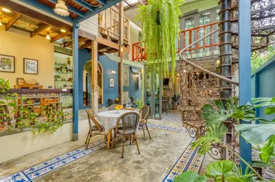a dining room with a table and chairs and plants at Priya Boutique House in Bangkok