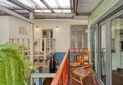 a porch with two chairs and a table at Priya Boutique House in Bangkok