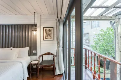 a bedroom with a bed and a balcony at Priya Boutique House in Bangkok