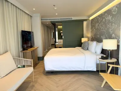 a hotel room with a large bed and a couch at The Quarter Chaophraya by UHG in Bangkok
