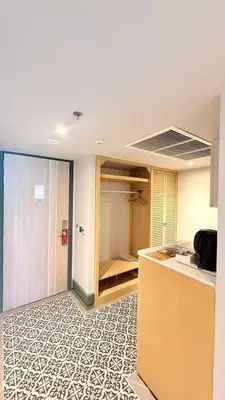 a room with a kitchen with a counter and a closet at The Quarter Chaophraya by UHG in Bangkok