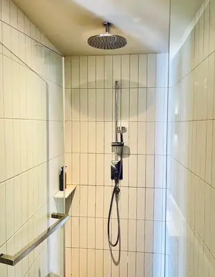 a shower in a bathroom with a shower head at The Quarter Chaophraya by UHG in Bangkok