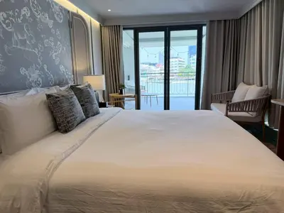 a bedroom with a large bed and a balcony at The Quarter Chaophraya by UHG in Bangkok
