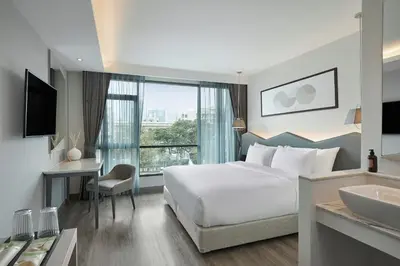 a hotel room with a bed and a sink at Livable Hotel Bangkok in Bangkok