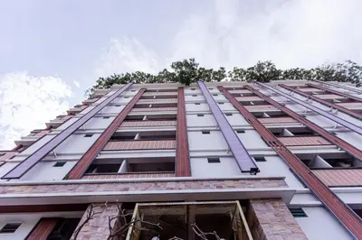 a tall white building with a ladder on it at Latin Garden Hotel in Bangkok