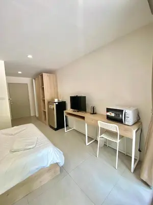 a bedroom with a bed and a desk with a microwave at POP Heritage Residence in Bangkok