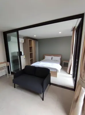 a bedroom with a bed and a black couch at POP Heritage Residence in Bangkok