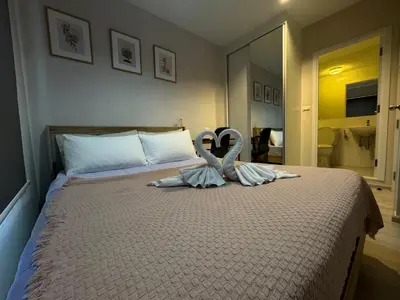 a bedroom with a bed with two swans on it at Plum central westgate@Bangyai in Ban Bang Krabu