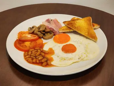 a plate of breakfast food with eggs bacon beans and toast at Lo-Ha Guest house, Contactless Check-in in Bangkok
