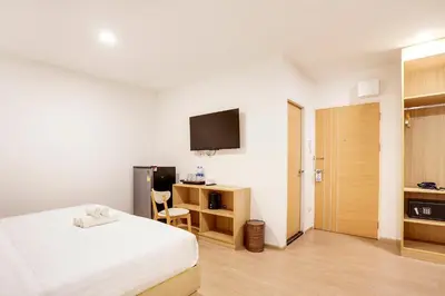 a bedroom with a bed and a tv on the wall at TAKKA Hotel - Bangna in Bangna