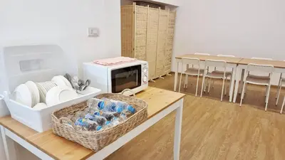 a kitchen with a microwave and a table with chairs at TAKKA Hotel - Bangna in Bangna