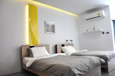 two beds sitting next to each other in a room at A23 residence in Bangkok