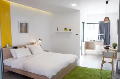 a bedroom with a bed and a desk with a chair at A23 residence in Bangkok