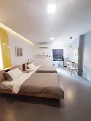 a bedroom with two beds and a table in it at A23 residence in Bangkok