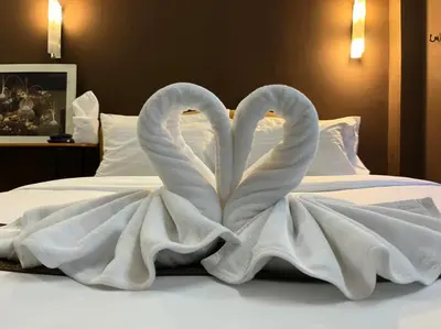 two swans made out of towels on a bed at Cozy rooms Asoke in Bangkok