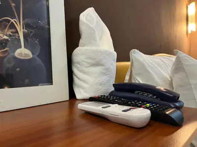 a phone and a remote control on a table at Cozy rooms Asoke in Bangkok