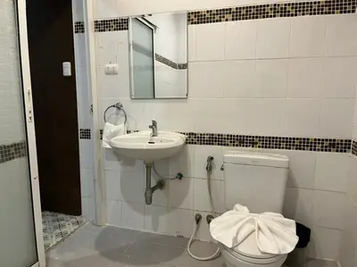a bathroom with a toilet and a sink at Cozy rooms Asoke in Bangkok