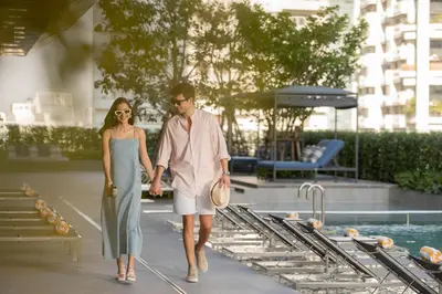 a man and a woman walking next to a pool at Staybridge Suites Bangkok Sukhumvit by IHG in Bangkok