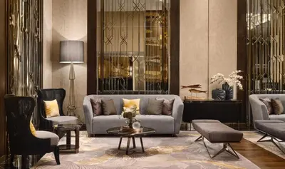 a living room with a couch and chairs and a table at Chatrium Grand Bangkok in Bangkok