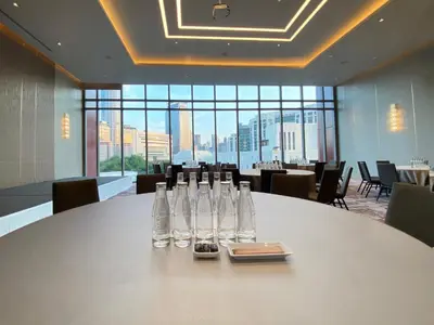 a conference room with a table with wine bottles on it at Chatrium Grand Bangkok in Bangkok
