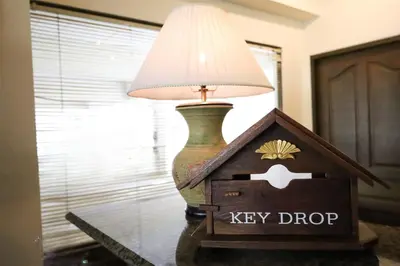 a lamp sitting on a table next to a keep drop box at Phawana Sweet Hotel in Bangkok