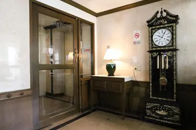 a clock on the wall in a room at Phawana Sweet Hotel in Bangkok