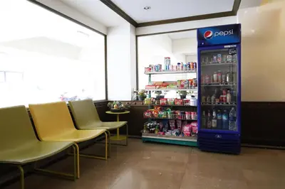 a soda vending machine in a restaurant with chairs at Phawana Sweet Hotel in Bangkok
