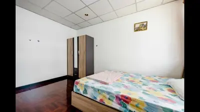 a bedroom with a bed with a colorful comforter at Flourish Apartments in Bangkok
