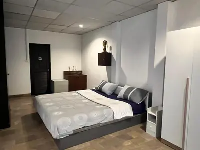 a bedroom with a large bed in a room at Flourish Apartments in Bangkok