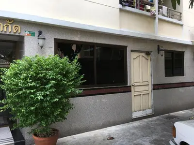 a building with a door and a tree in front of it at S.K. Residence in Bangkok
