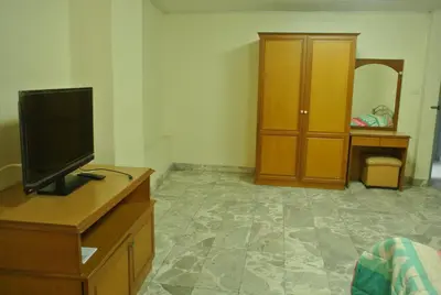 a living room with a tv on a wooden dresser at S.K. Residence in Bangkok