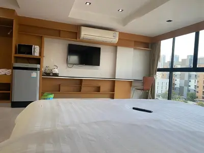 a bedroom with a white bed and a tv at L18 residence แอลสิบแปด เรสซิเดนซ์ in Ban Zong Katiam