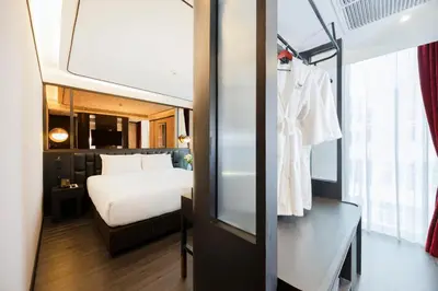 a hotel room with a bed and a mirror at The Gravitique Hotel Khaosan in Bangkok